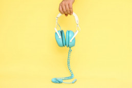 casque bleu sur fond jaune pour écouter des podcasts