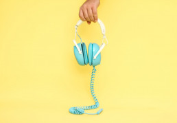 casque bleu sur fond jaune pour écouter des podcasts